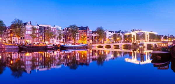 Magere Brug Bridge And Canal Side Houses On The Amstel River At Twilight, Amsterdam, Netherlands