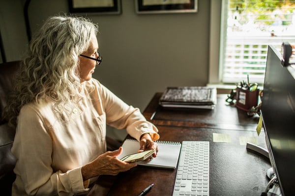 Mature Woman Using Smartphone In Home Office