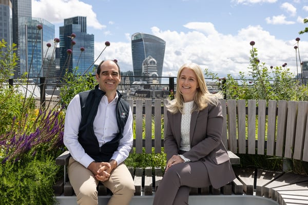 Antonio Simões, Group CEO, and Zoe Wimborne, Group CRO, on a rooftop terrace overlooking the City of London skyline.