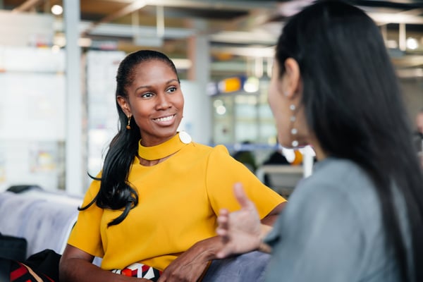 Two employees in conversation in a modern office setting