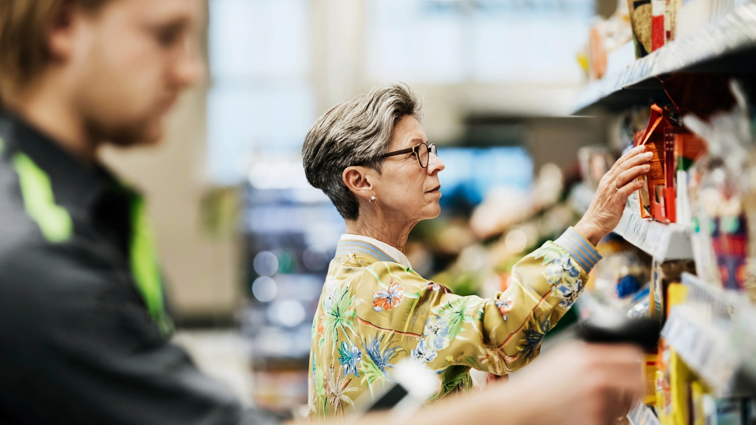 middle aged female with glasses and short hair picking grocery from grocery store middle aged female with glasses and short hair picking grocery from grocery store
