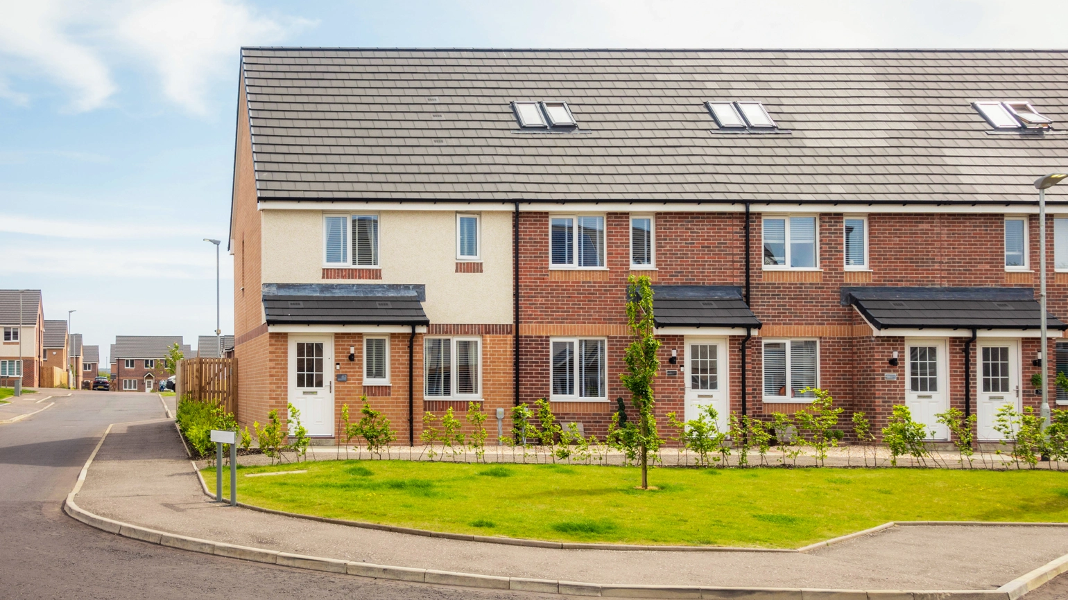 A housing estate in Irvine, Scotland, with modern brick built terraced houses in the foreground, and detached houses in the distance. A housing estate in Irvine, Scotland, with modern brick built terraced houses in the foreground, and detached houses in the distance.
