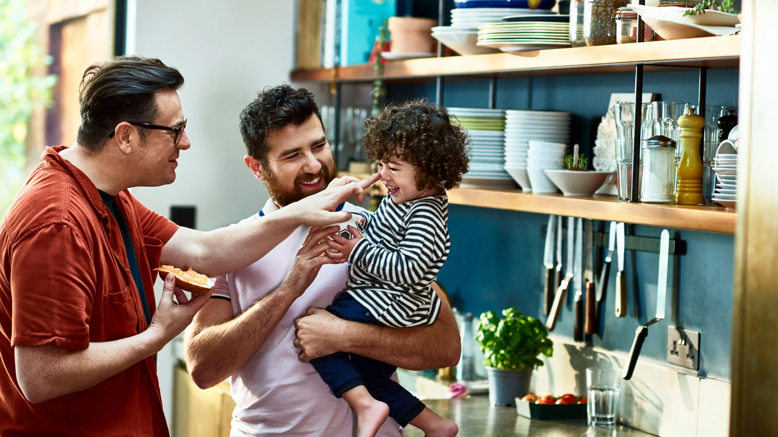 Male couple with their daughter in their kitchen Male couple with their daughter in their kitchen