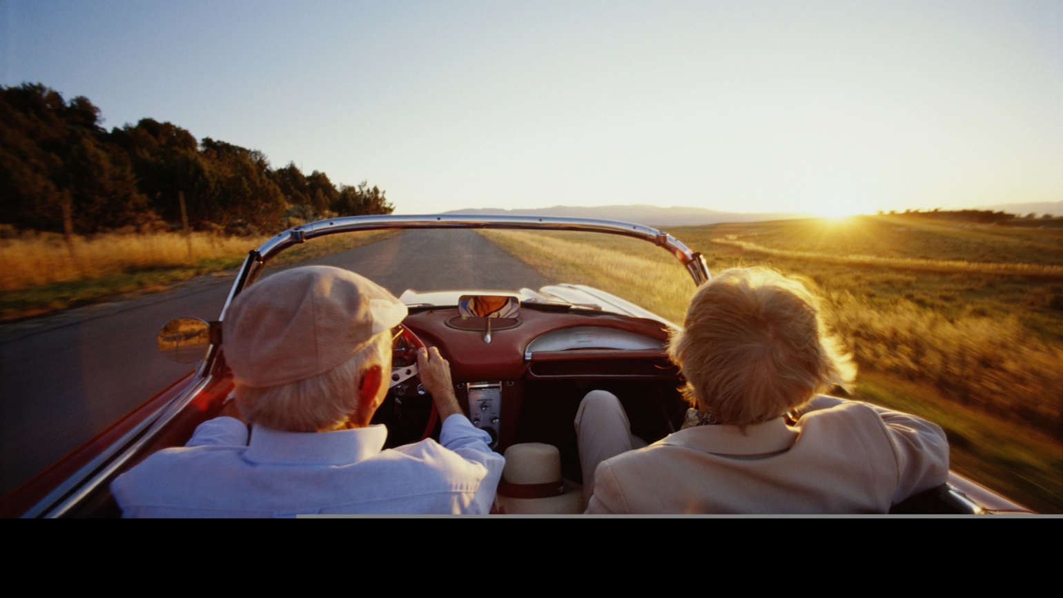 Elderly couple driving car with roof down  Elderly couple driving car with roof down