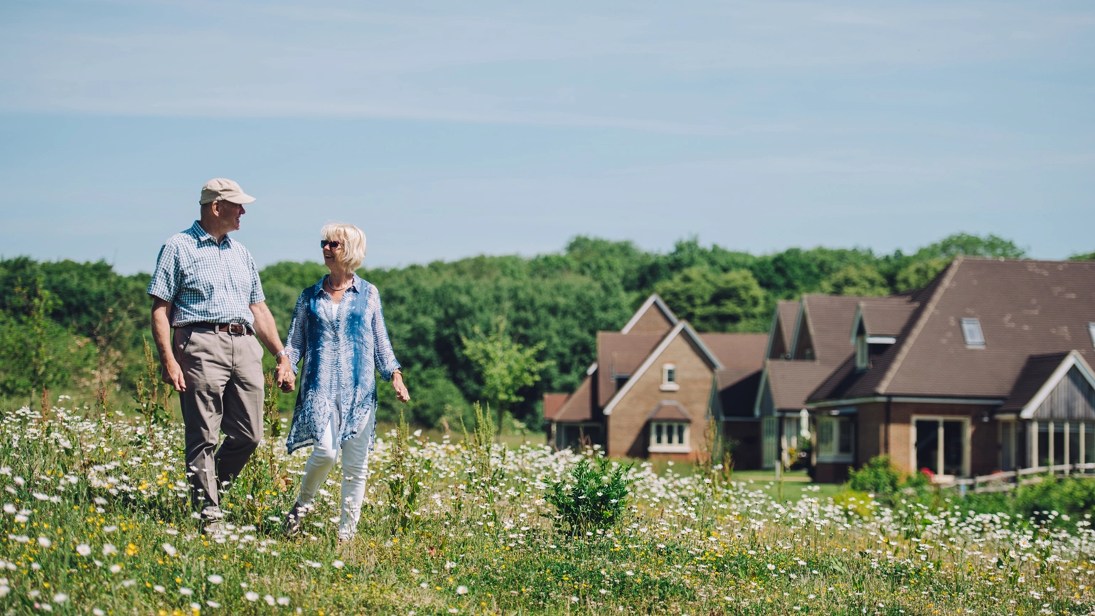 Elderly couple walking on the hill near town homes Elderly couple walking on the hill near town homes