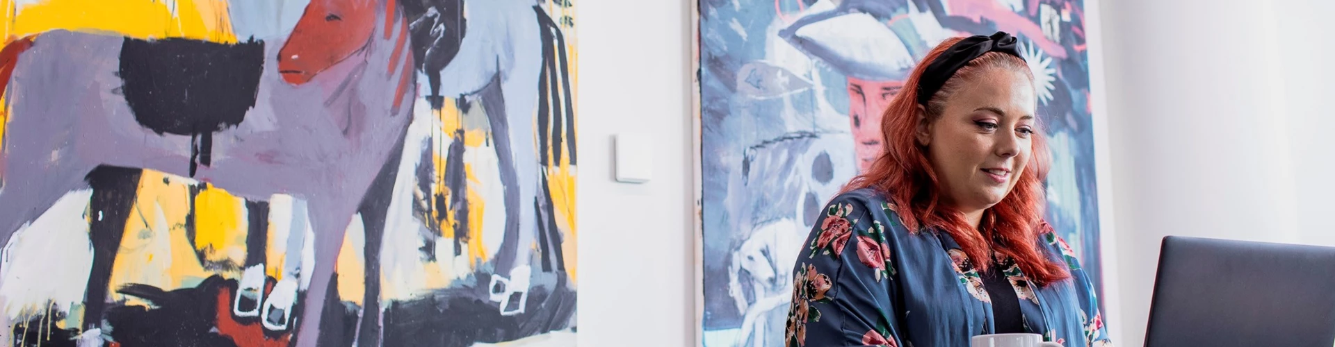 Women working in front of painting on her laptop