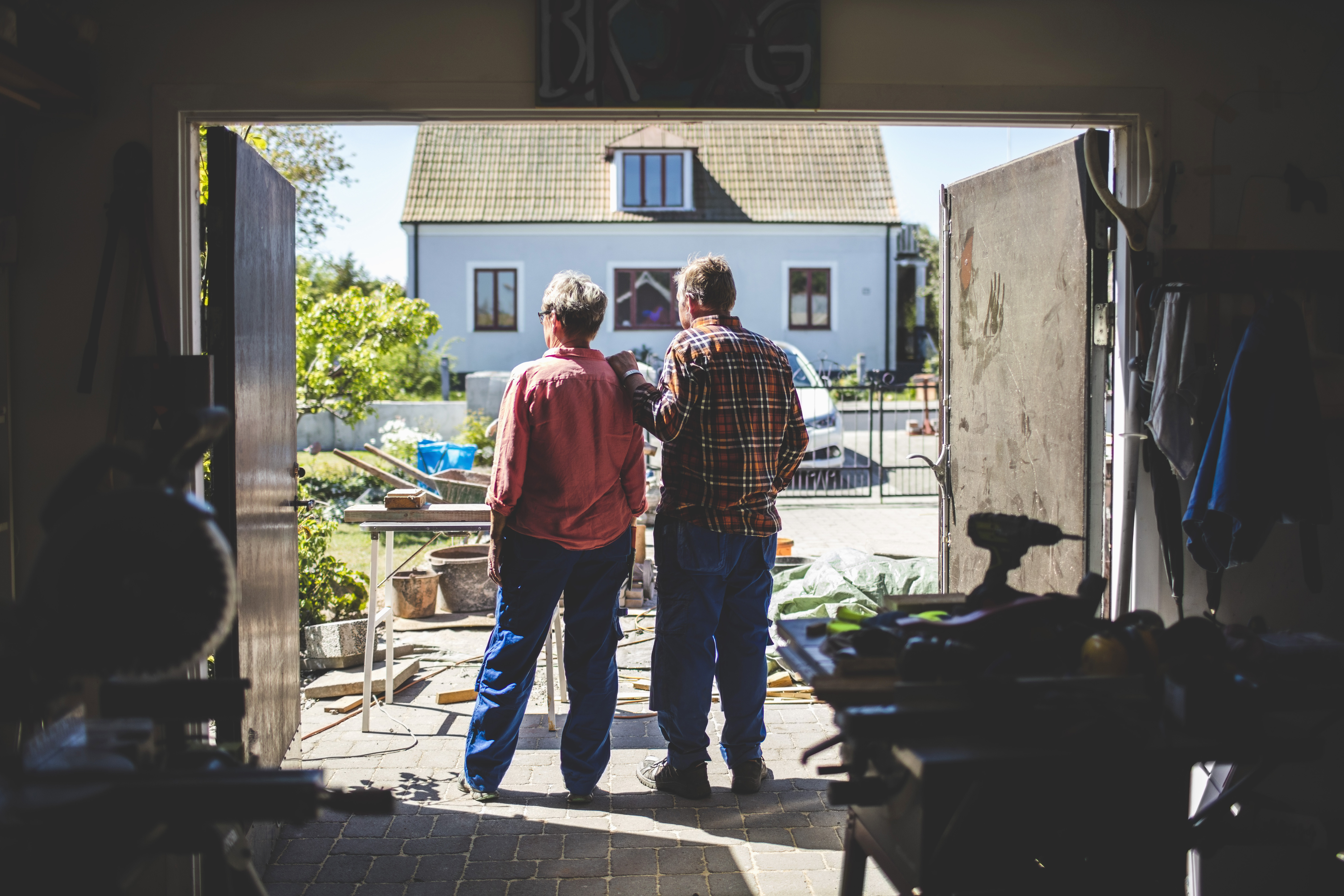 Elderly couple in their garage looking outside
