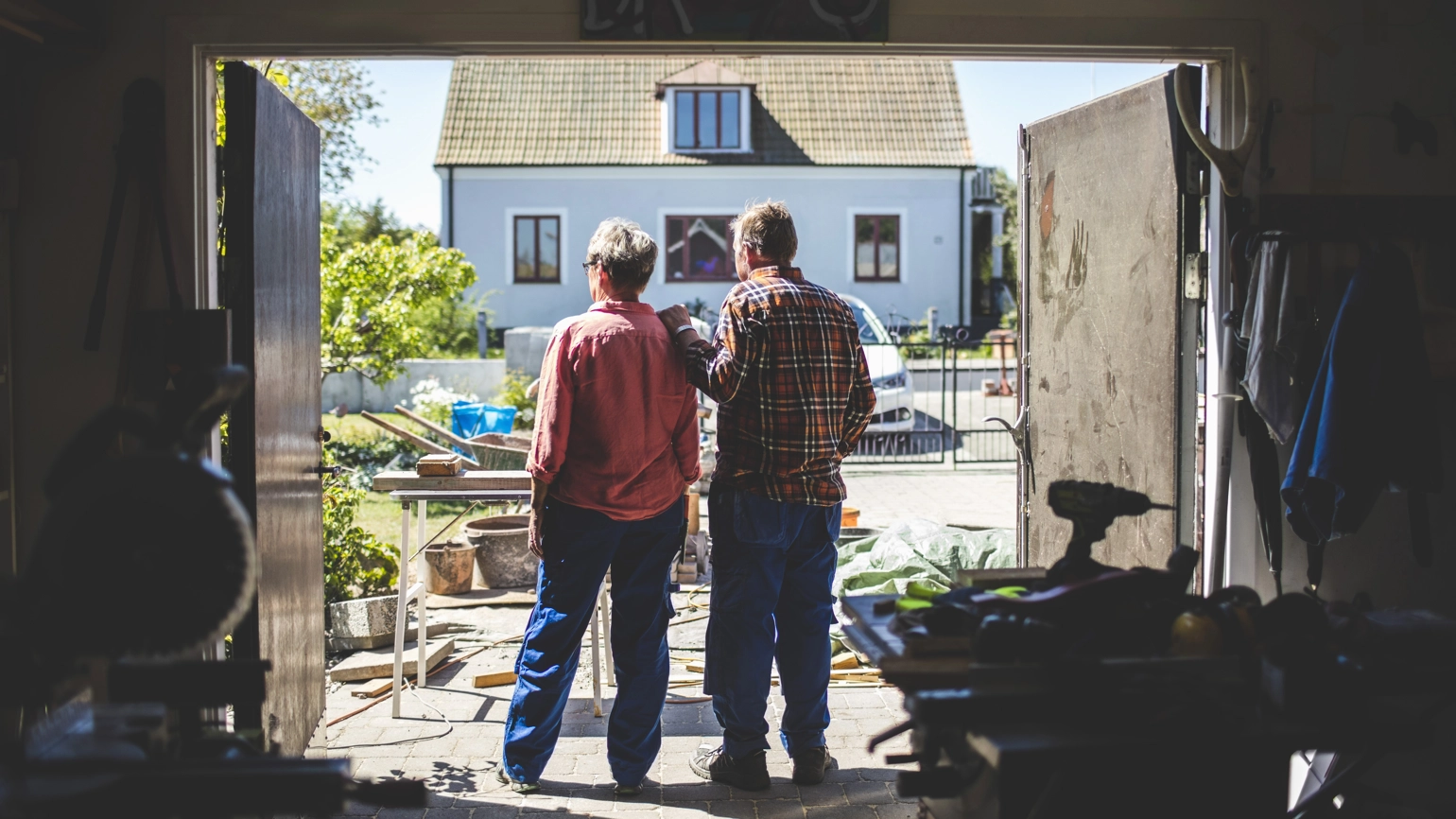 Elderly couple in their garage looking outside Elderly couple in their garage looking outside