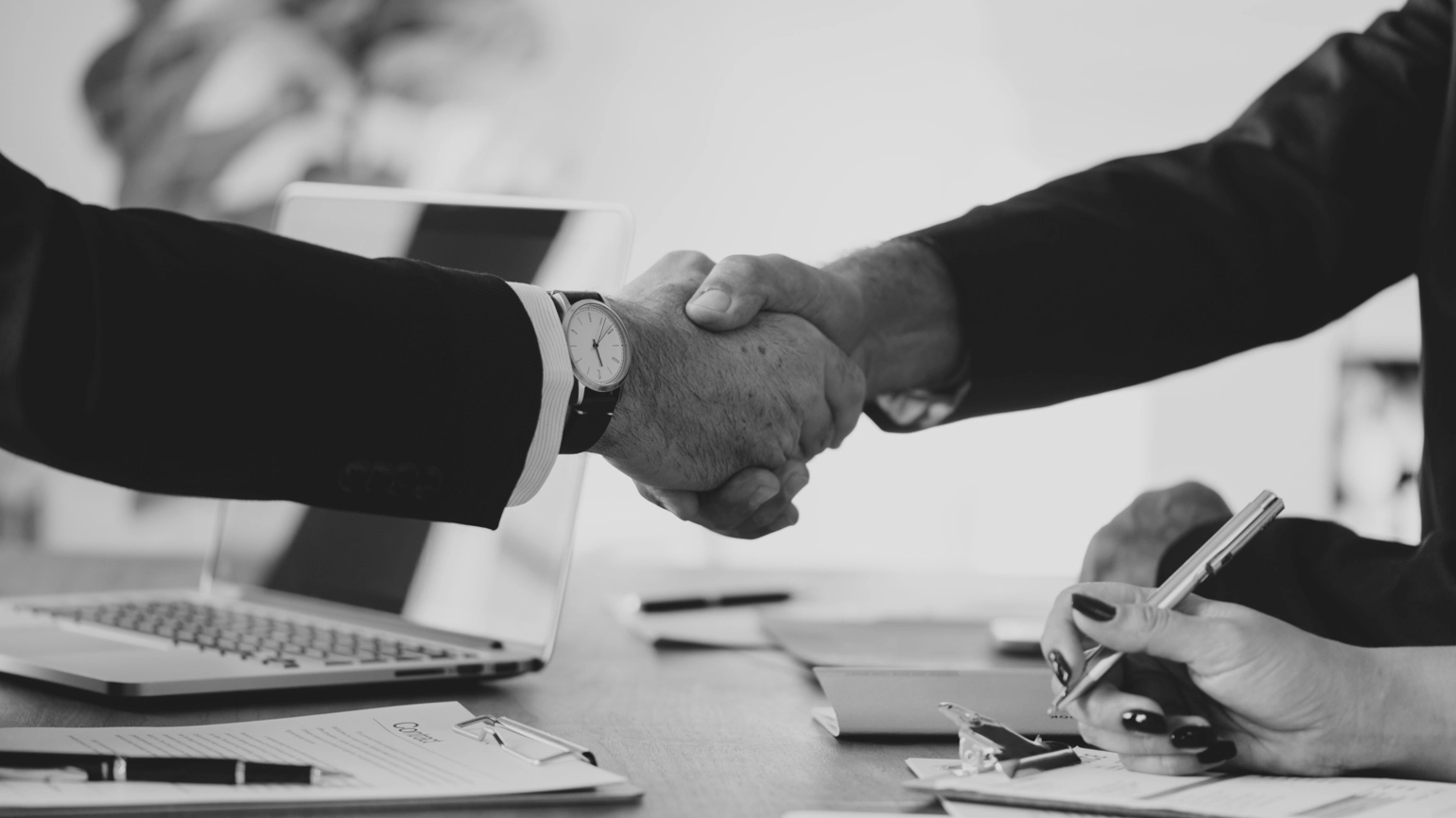 Two people shaking hands in black and white image Two people shaking hands in black and white image