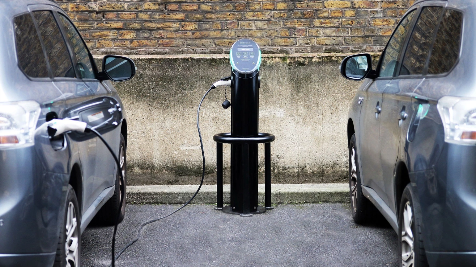 Photograph of a car plugged into electric charging point Photograph of a car plugged into electric charging point