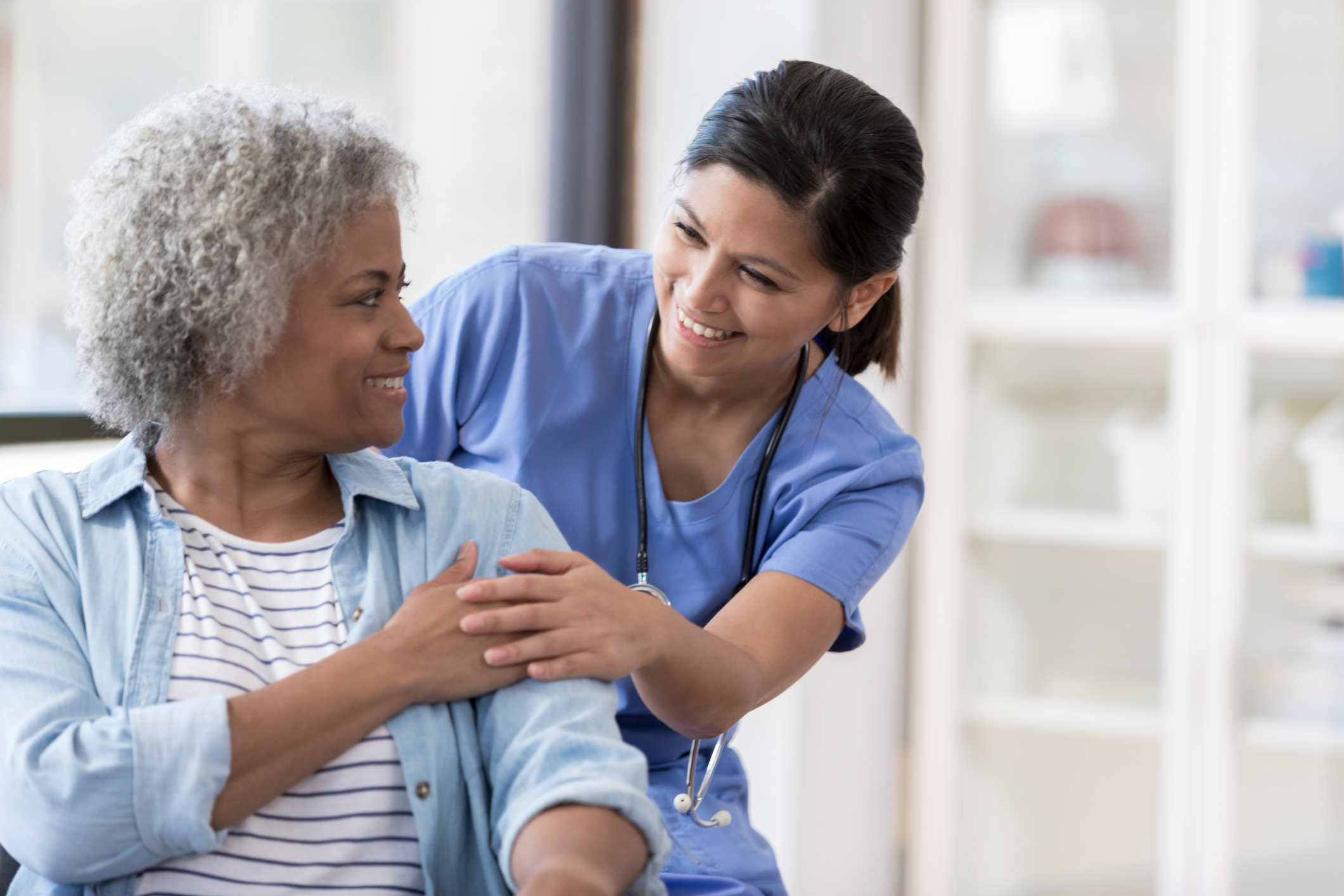 Female doctor checking her elderly female patient 