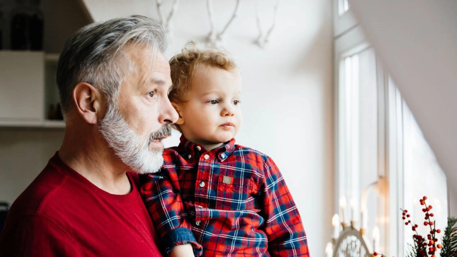 Grandfather and a grandson looking through the window Grandfather and a grandson looking through the window