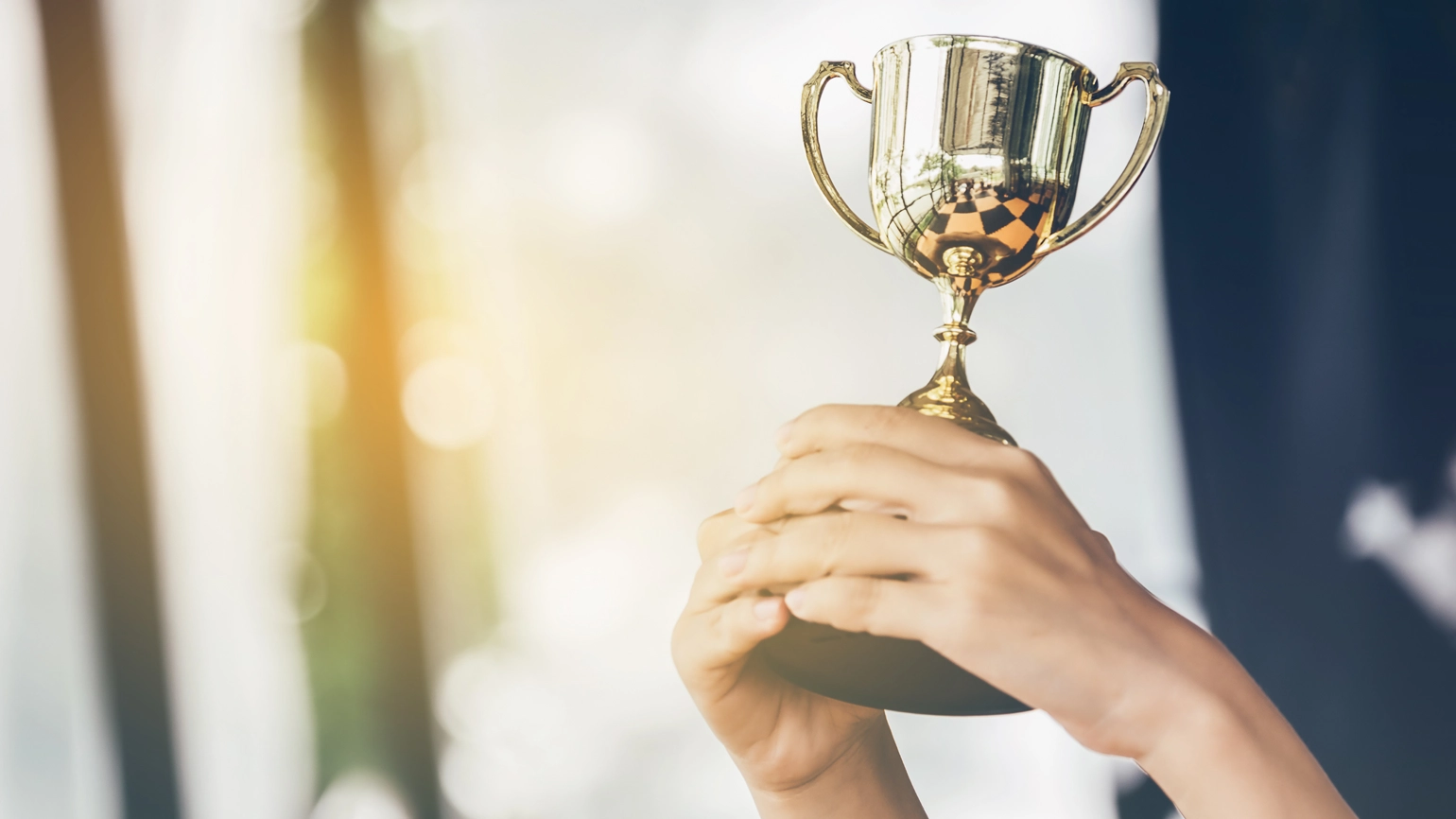 Hand holding trophy Hand holding trophy