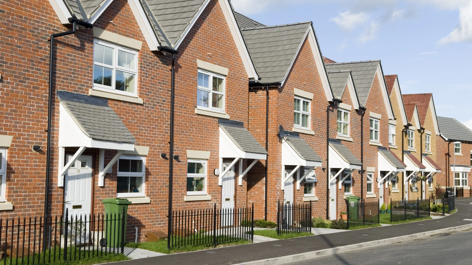A row of terraced houses, with pristine green front gardens. A row of terraced houses, with pristine green front gardens.