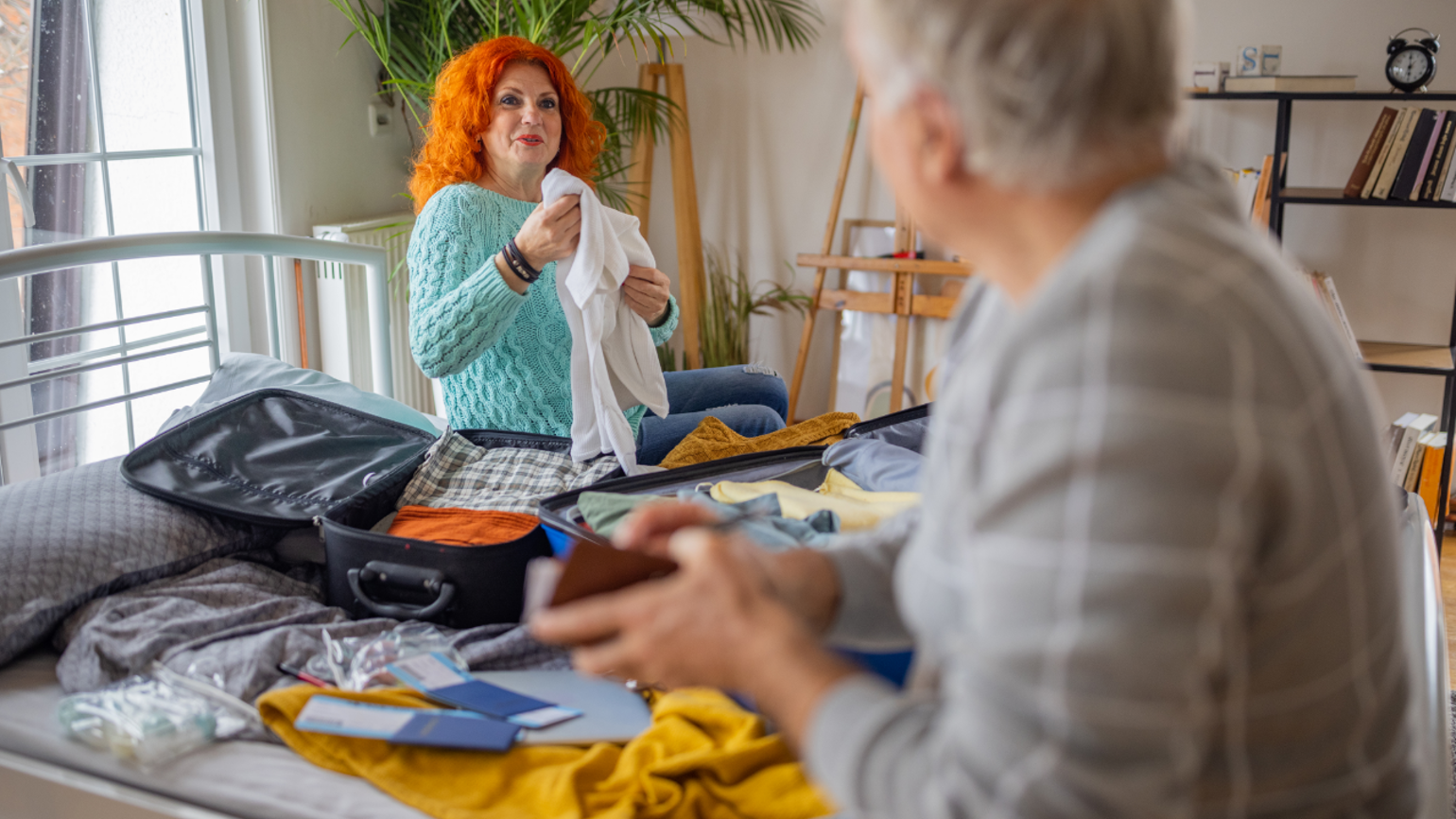 Two female packing their holiday suitcase Two female packing their holiday suitcase