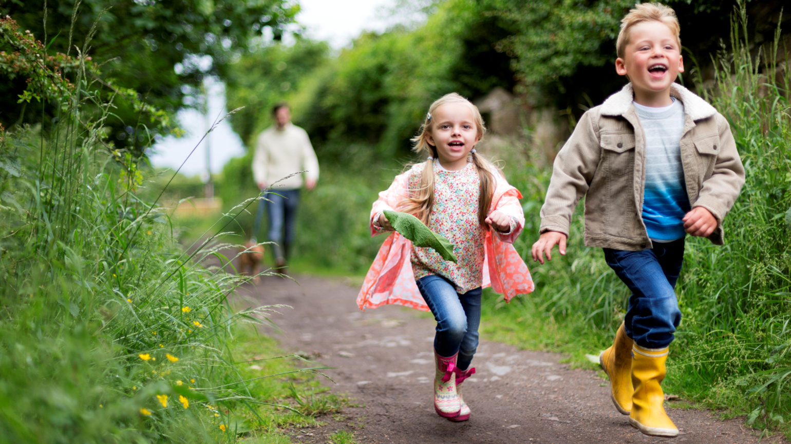 Two kids walking front and dad and dog coming behind Two kids walking front and dad and dog coming behind
