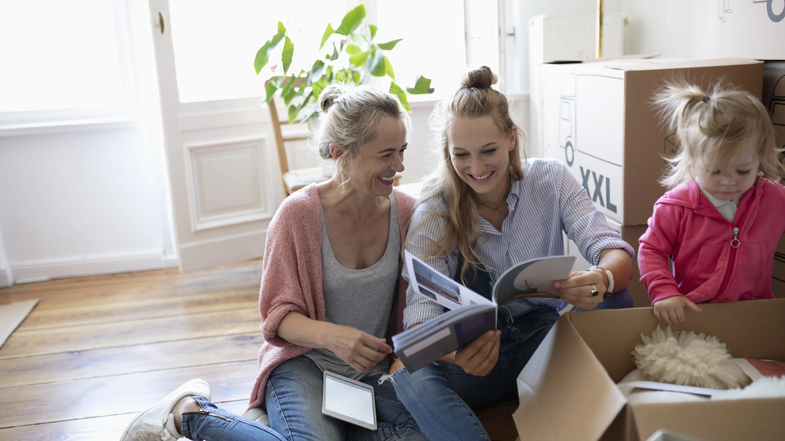 Grandmother, daughter and a grand daughter opening box and smiling Grandmother, daughter and a grand daughter opening box and smiling