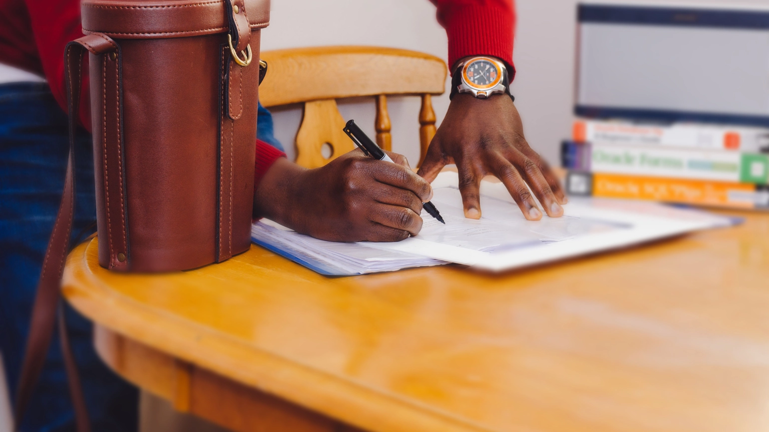 male signing paper work in his desk male signing paper work in his desk