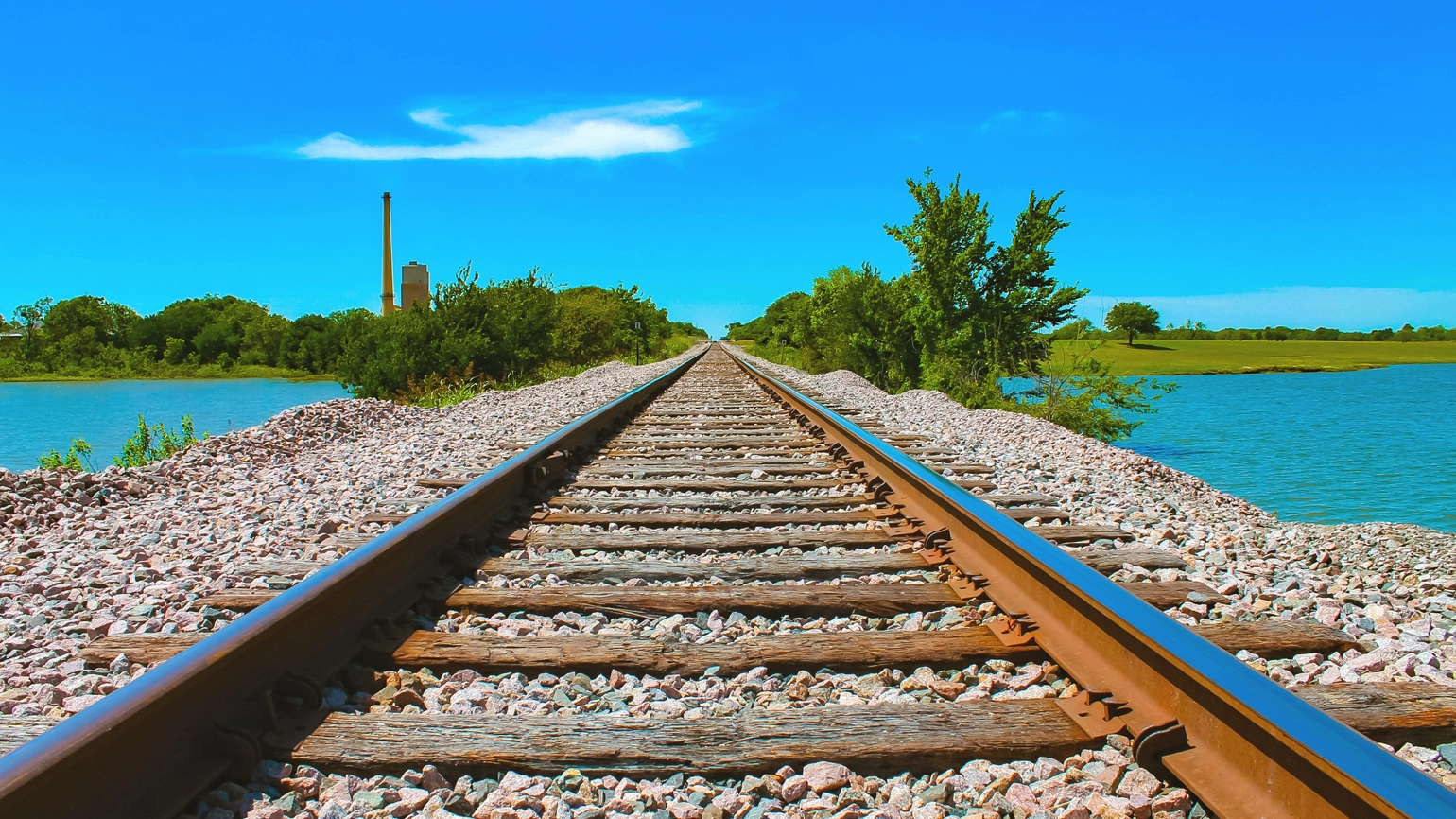 Railroad tracks near river in a clear weather Railroad tracks near river in a clear weather
