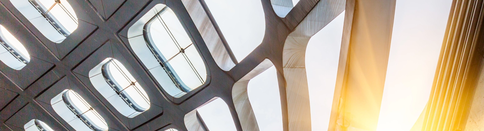 Close-up view of a contemporary building facade featuring glass panels and steel beams.  Close-up view of a contemporary building facade featuring glass panels and steel beams.