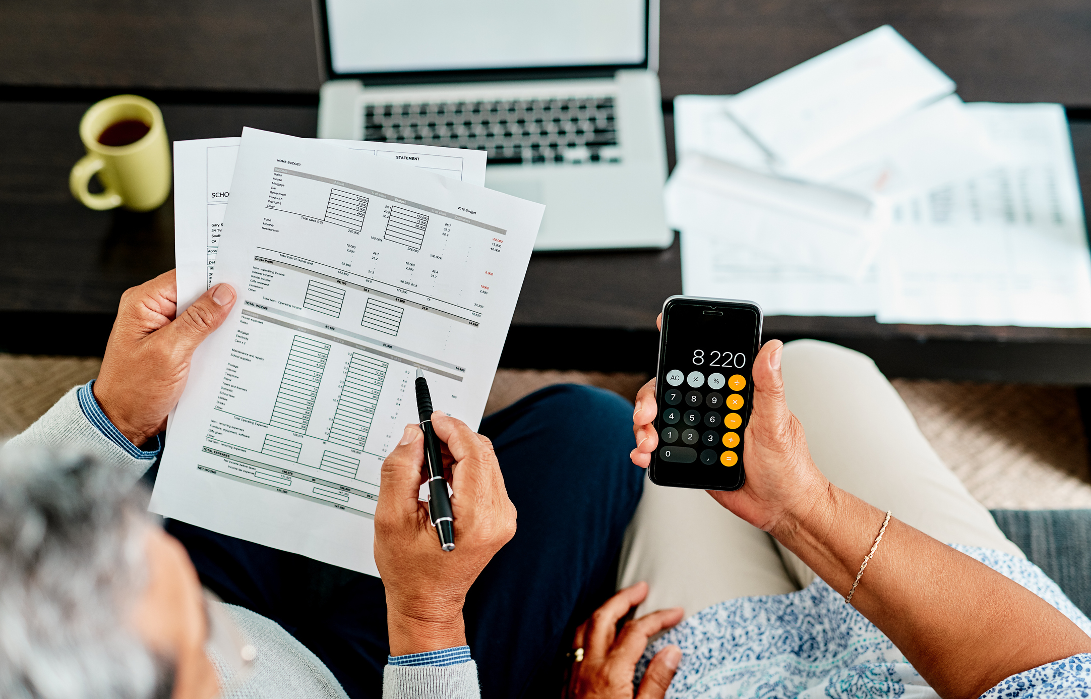 Elderly couple checking their bills and using calculator 
