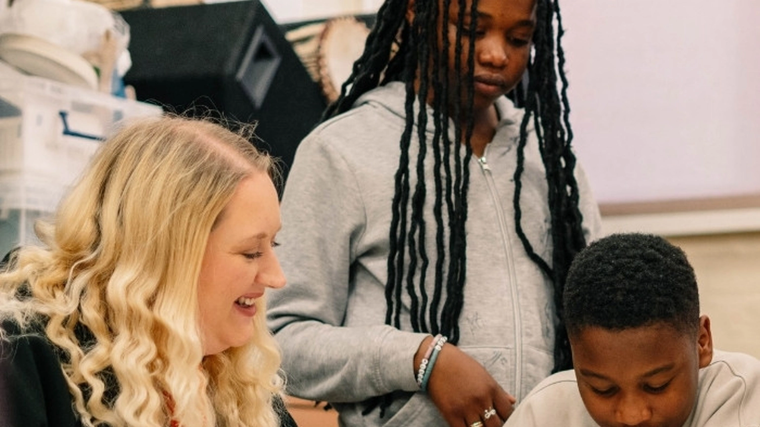 Two young people working on a project with a community leader. Two young people working on a project with a community leader.