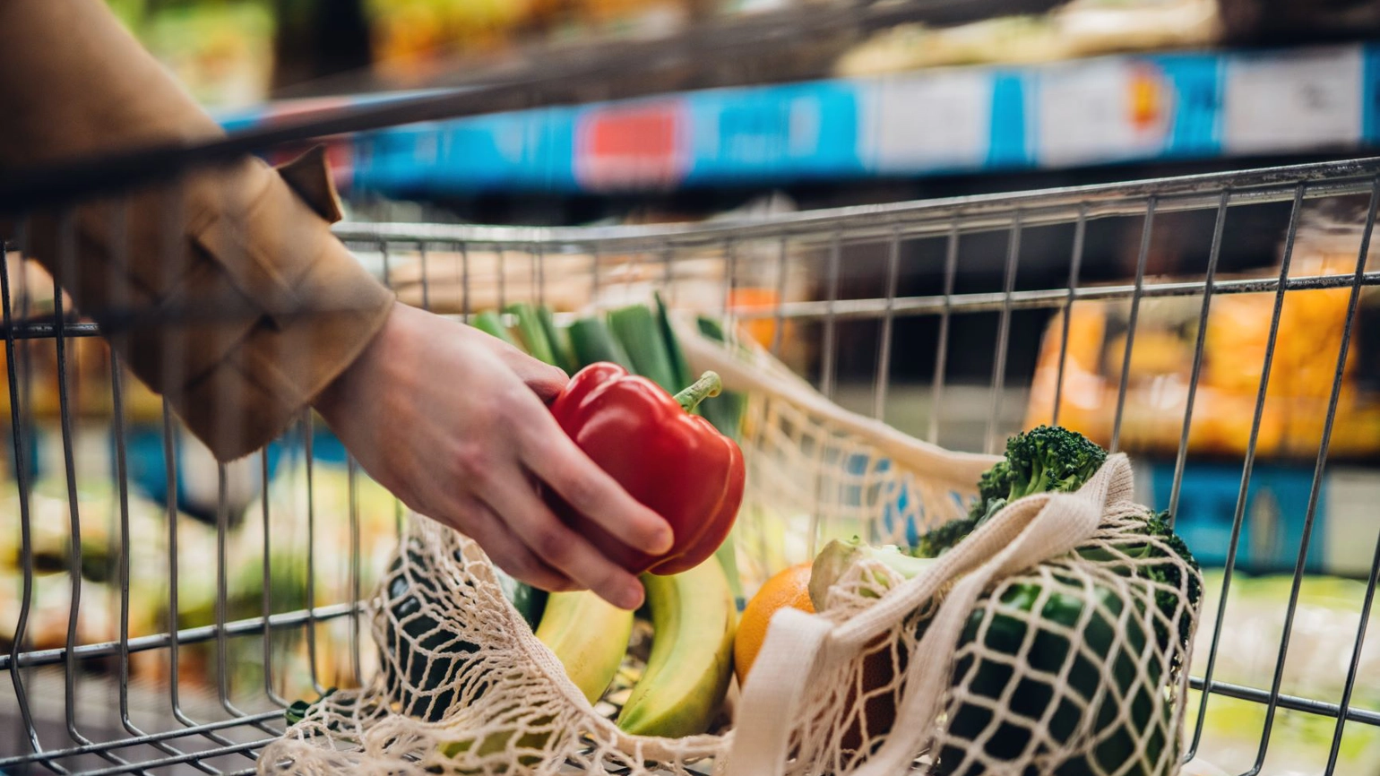 hands picking up groceries and placing in the trolley hands picking up groceries and placing in the trolley