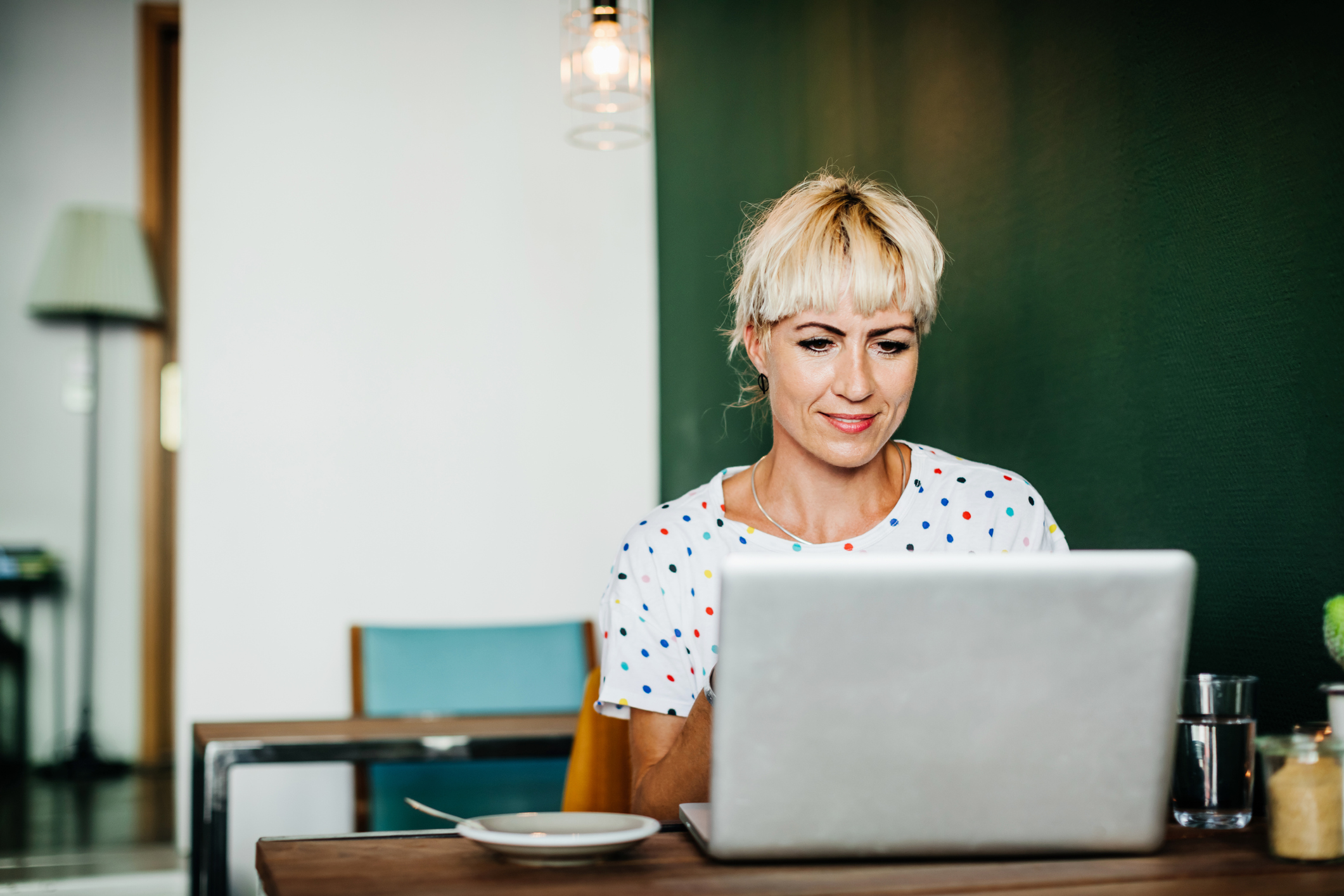 Female checking her laptop in dining table 