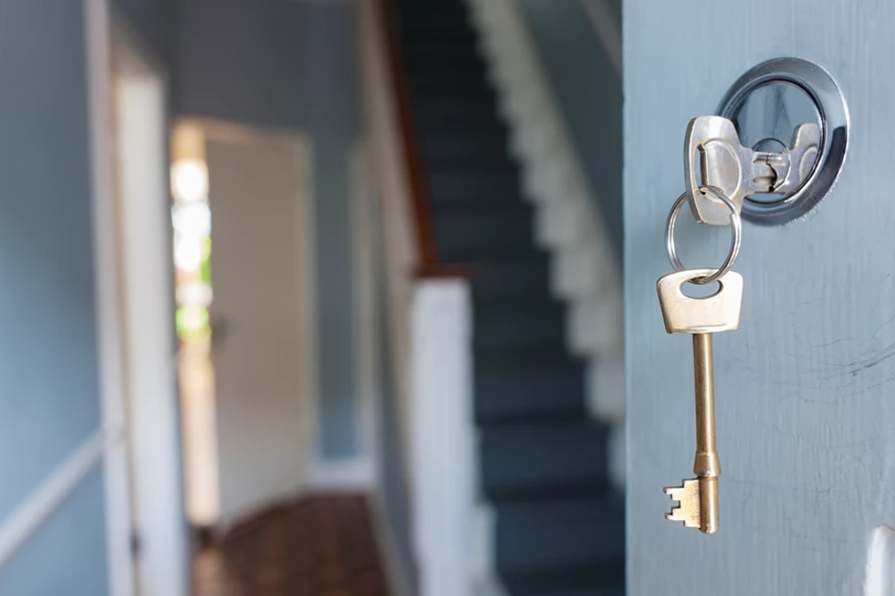 Image of a key on the front door of the house Image of a key on the front door of the house