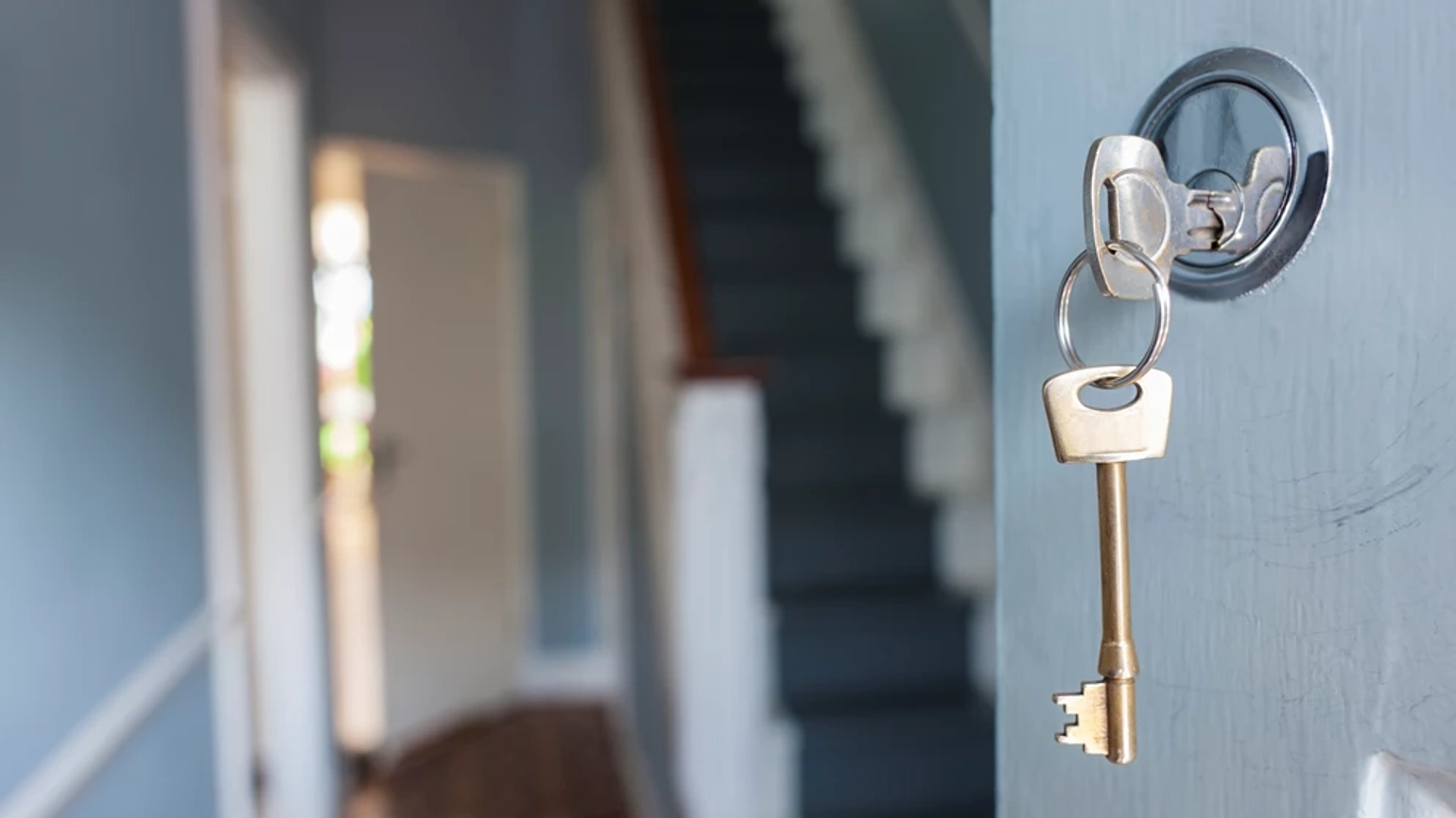Image of a key on the front door of the house Image of a key on the front door of the house
