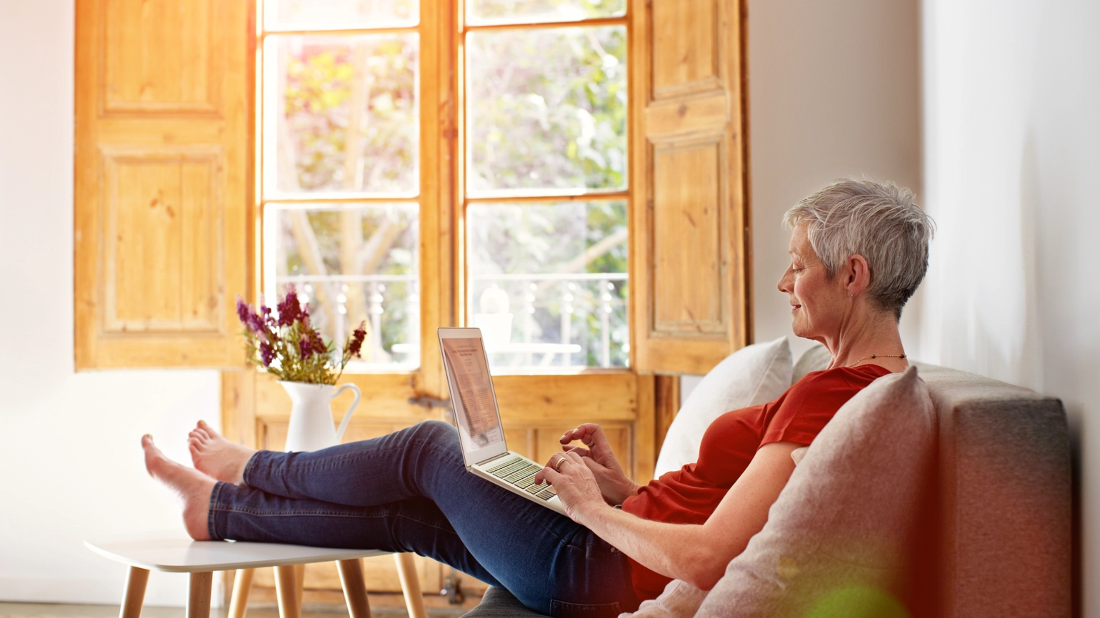 Elderly female checking laptop in her living room  Elderly female checking laptop in her living room