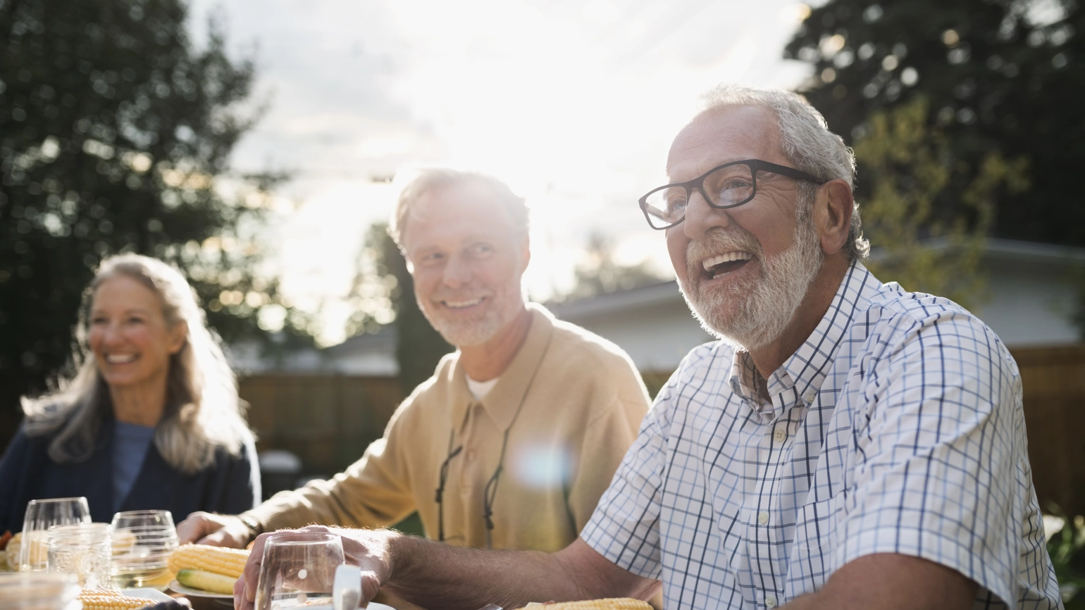 Photograph of friends at a BBQ laughing and joking Photograph of friends at a BBQ laughing and joking