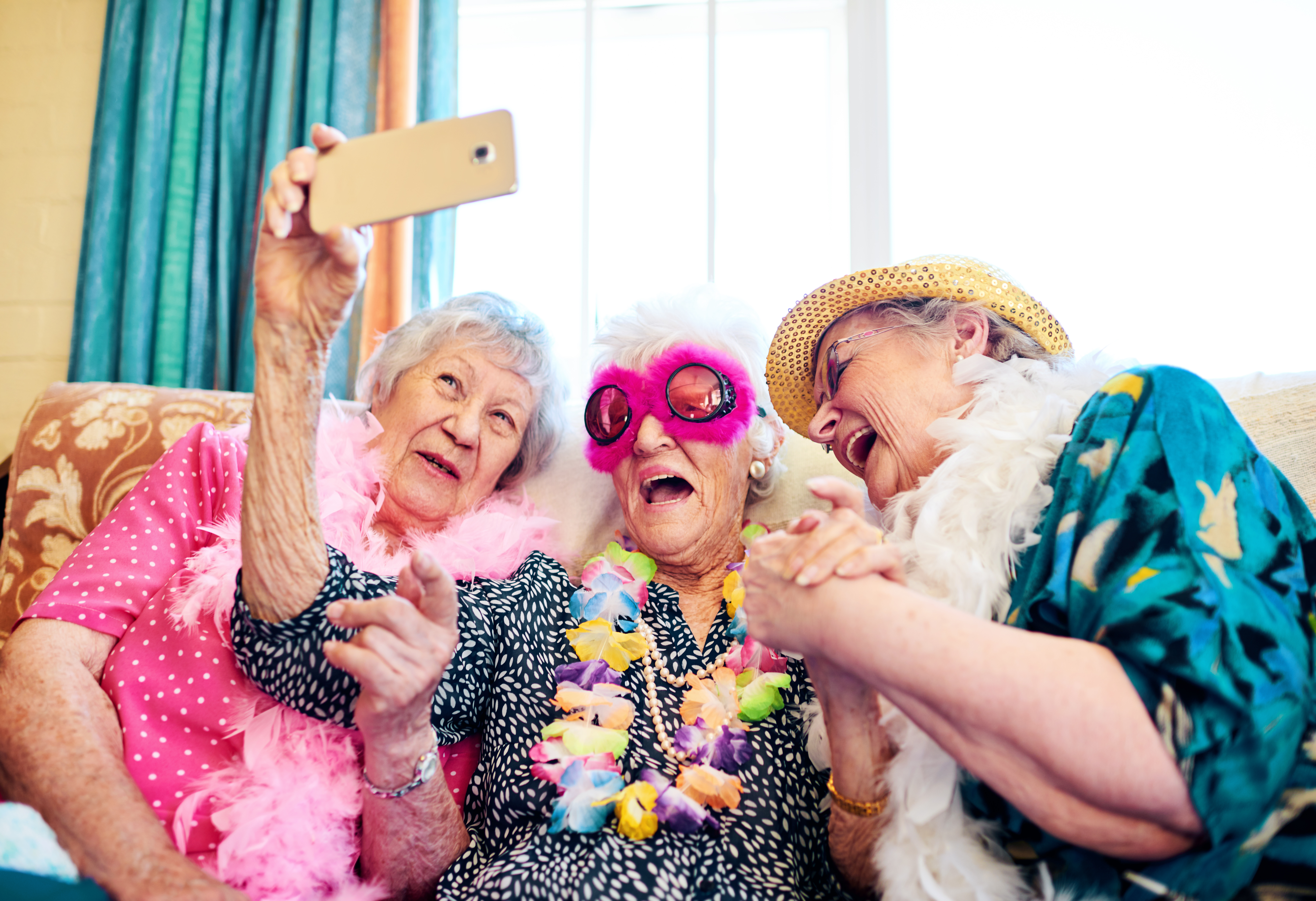 Group of elderly female friends taking photo with holiday clothes and accessories