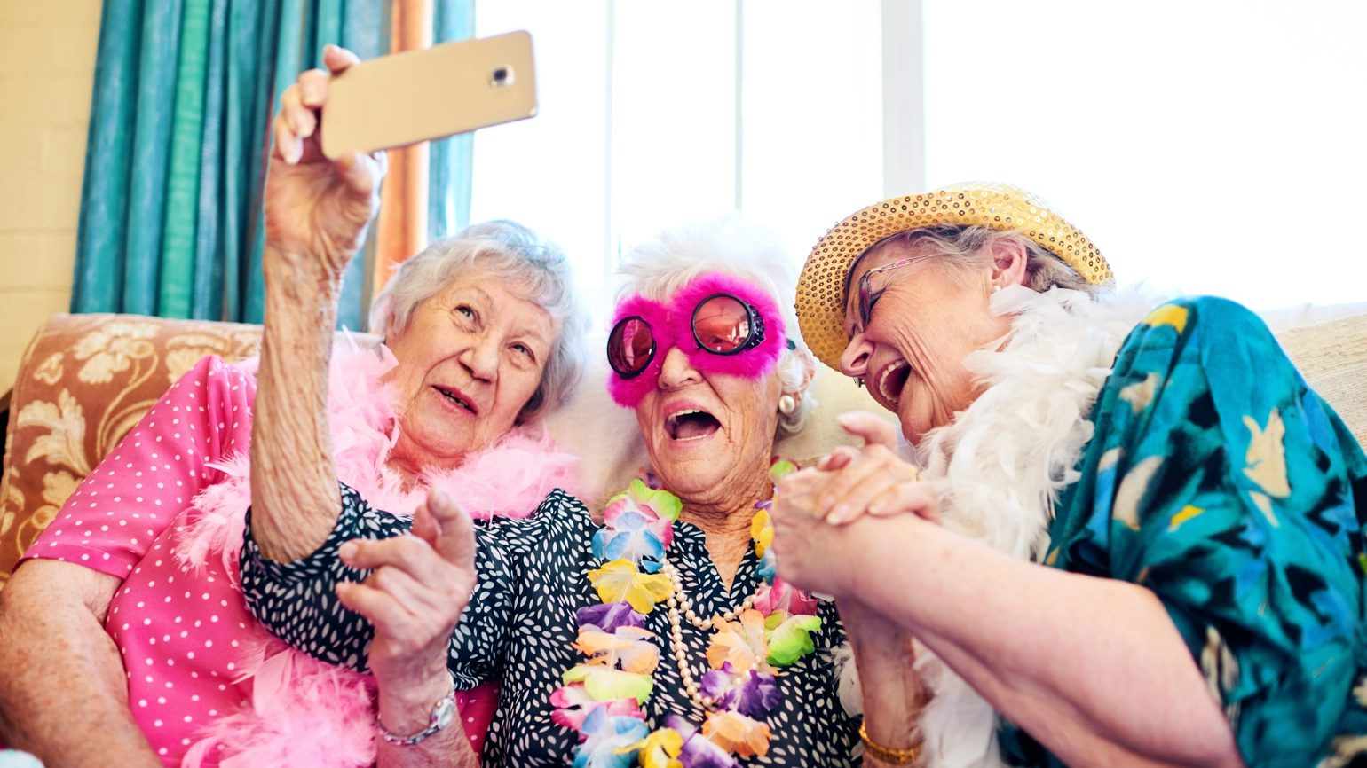 Group of elderly female friends taking photo with holiday clothes and accessories Group of elderly female friends taking photo with holiday clothes and accessories