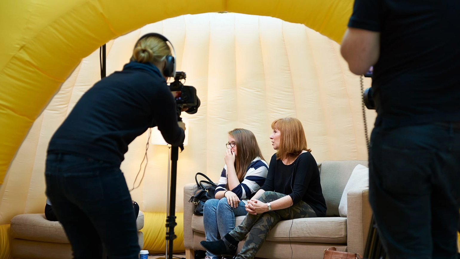 Female photographer taking two female a photo from photo booth Female photographer taking two female a photo from photo booth