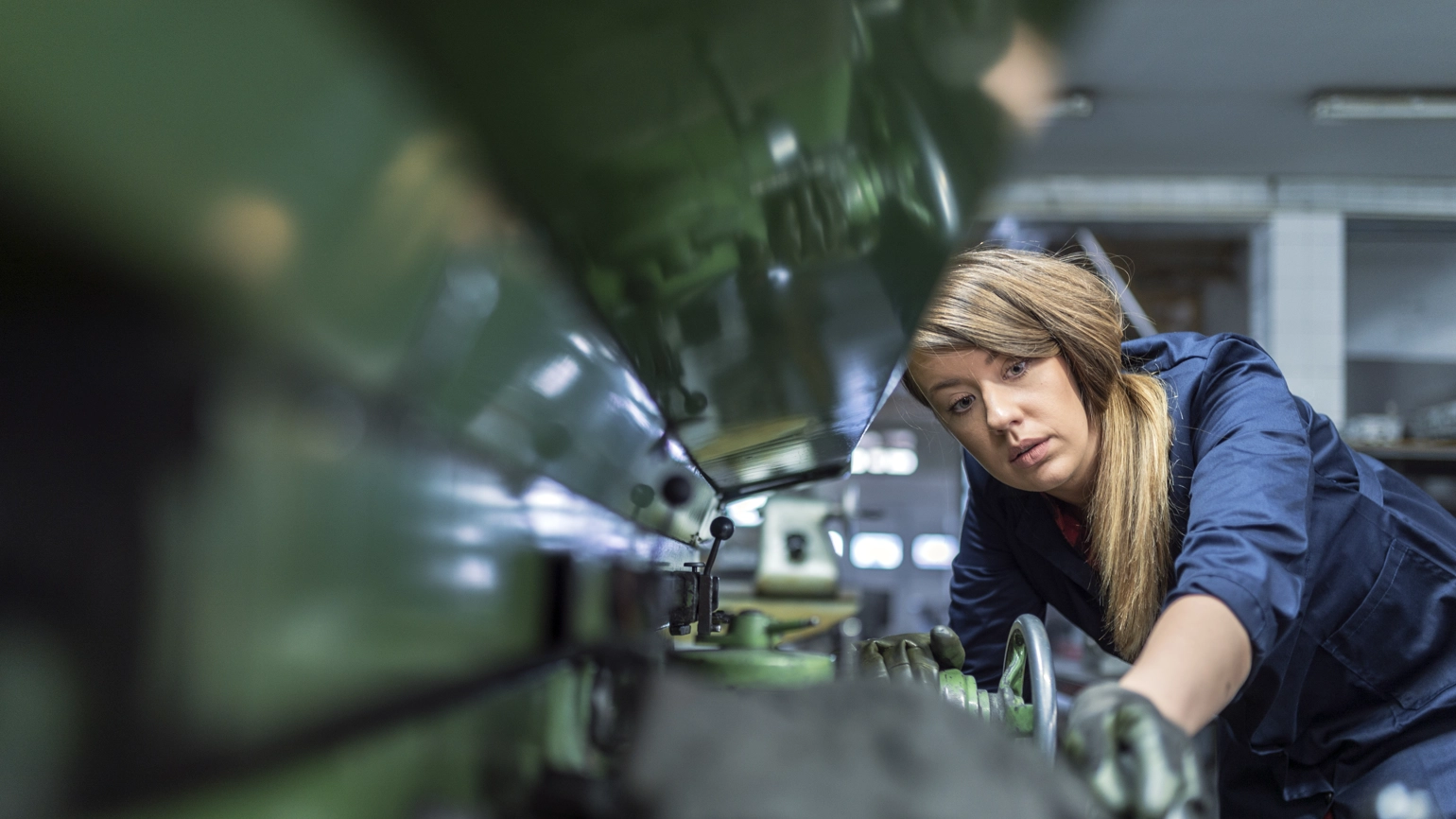 Person operating an industrial machine in a workshop. Person operating an industrial machine in a workshop.