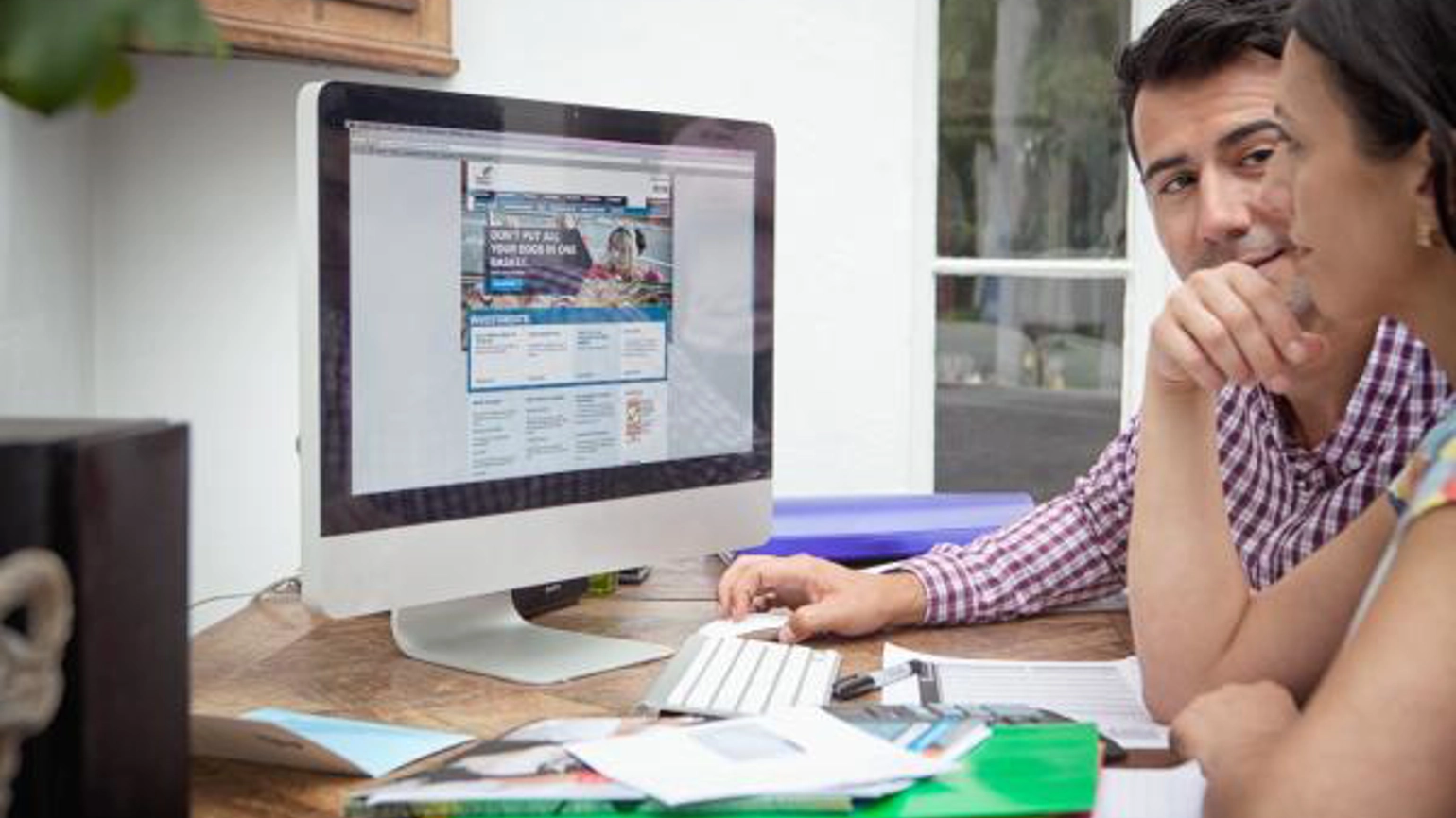 Two people checking computer monitor together while working Two people checking computer monitor together while working