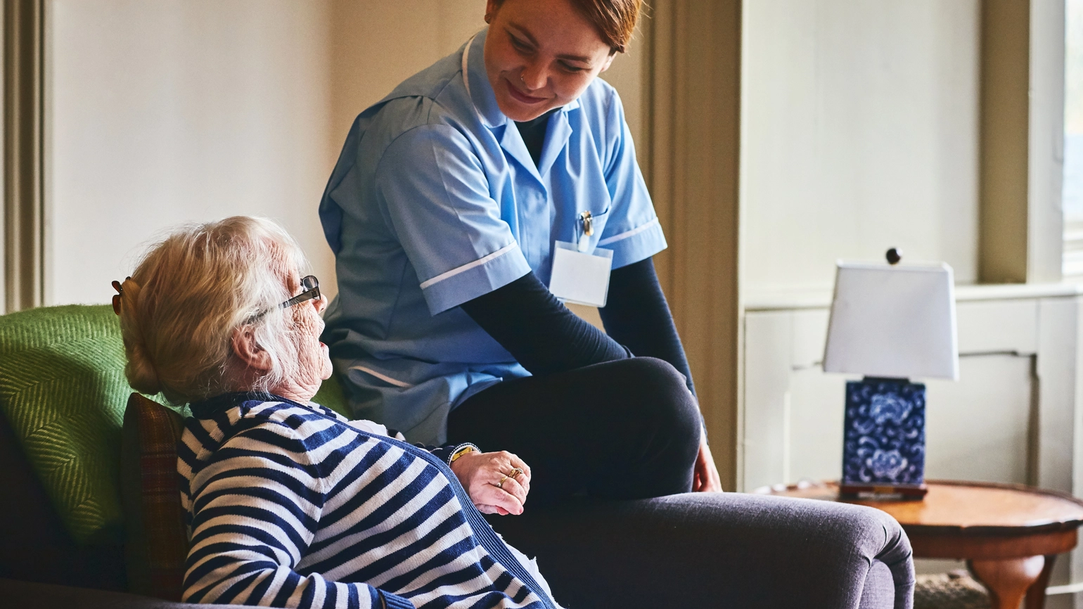 Female nurse chatting with elderly female patient Female nurse chatting with elderly female patient