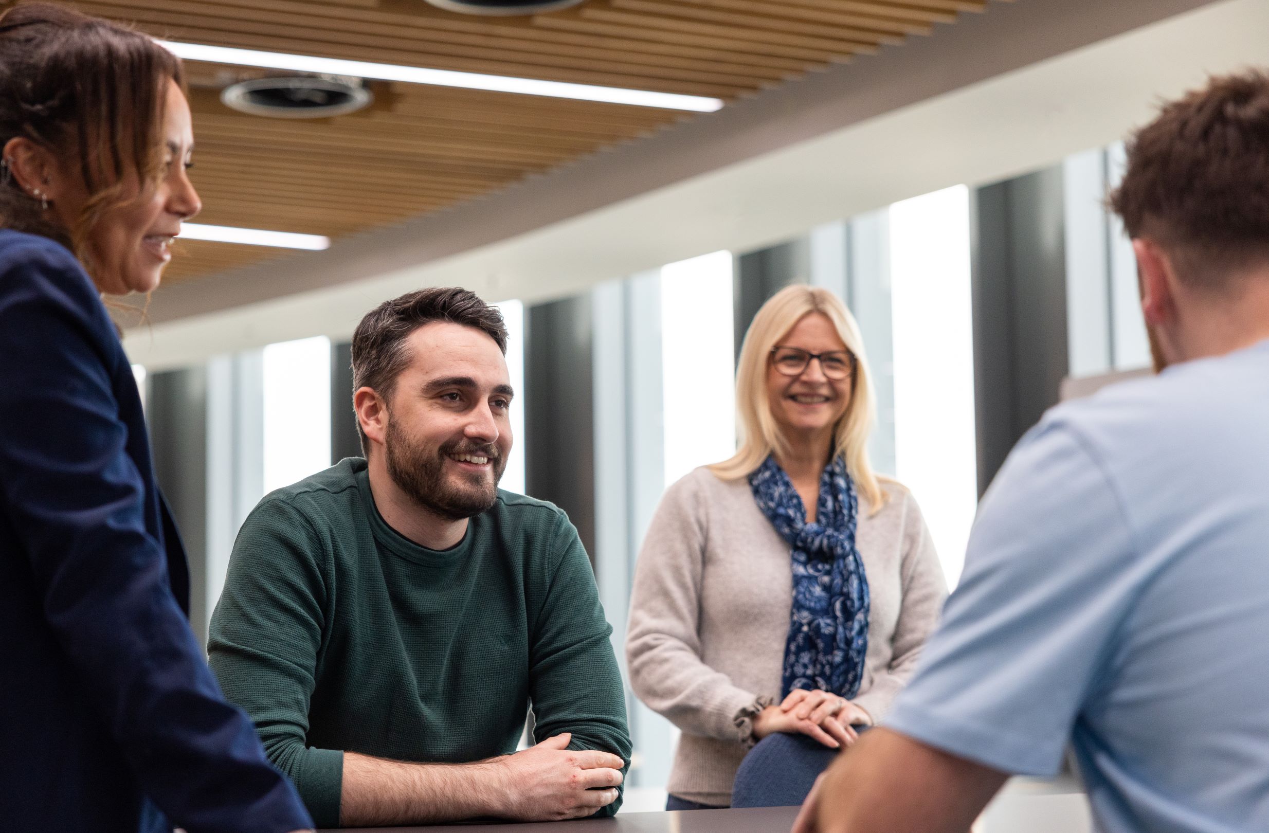 A group of colleagues sitting around a table inside Legal & General's Cardiff office.