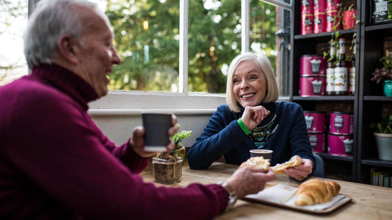 Elderly couple chatting with their coffee and pastries in cafe Elderly couple chatting with their coffee and pastries in cafe