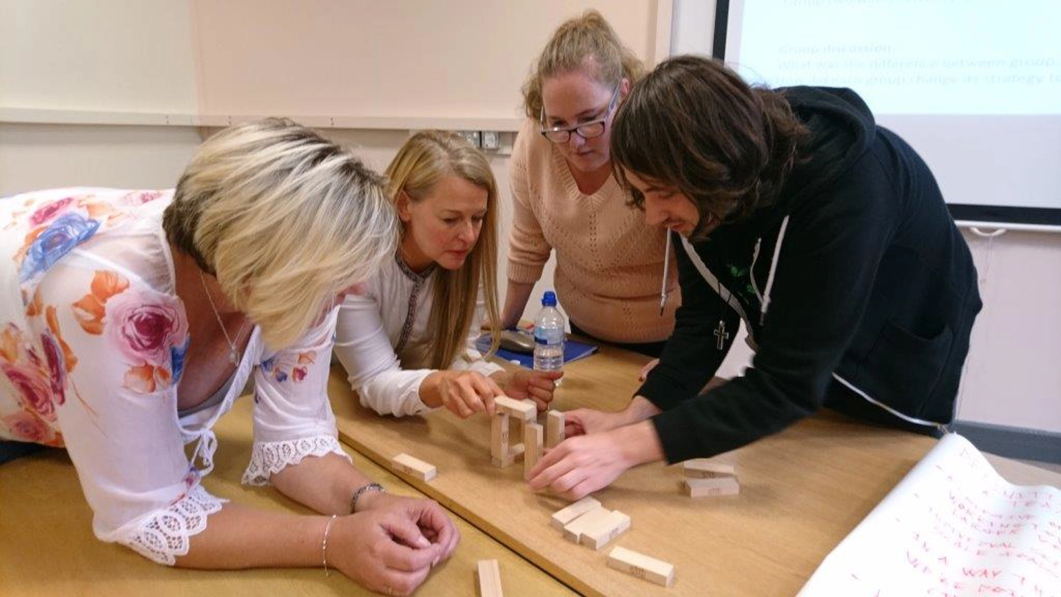 People building small bricks together People building small bricks together
