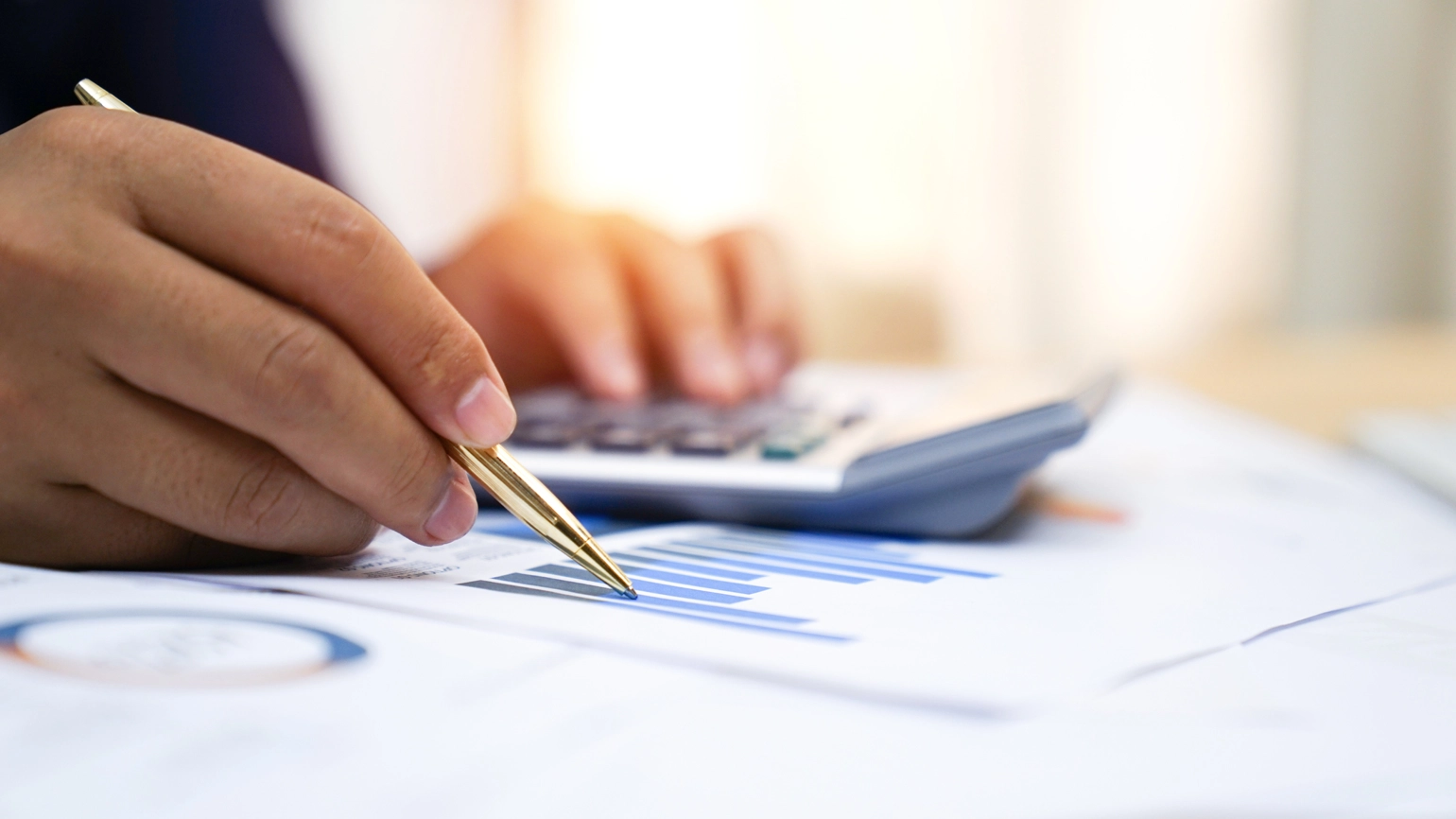 Hand checking chart and numbers with calculator Hand checking chart and numbers with calculator