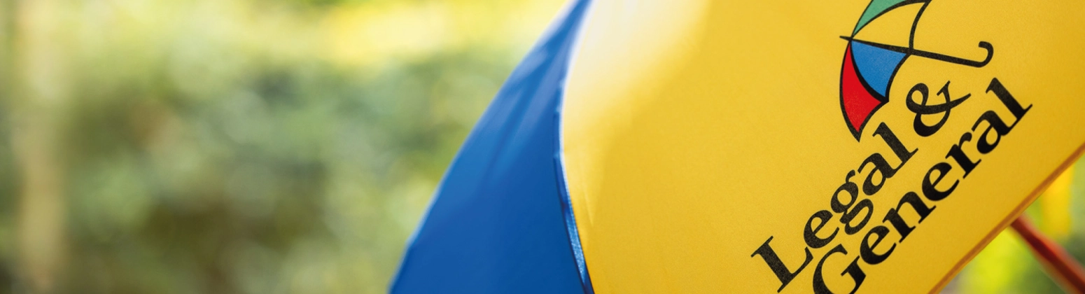 A close up of a colourful Legal & General umbrella, in a sunny and green outdoor setting. A close up of a colourful Legal & General umbrella, in a sunny and green outdoor setting.
