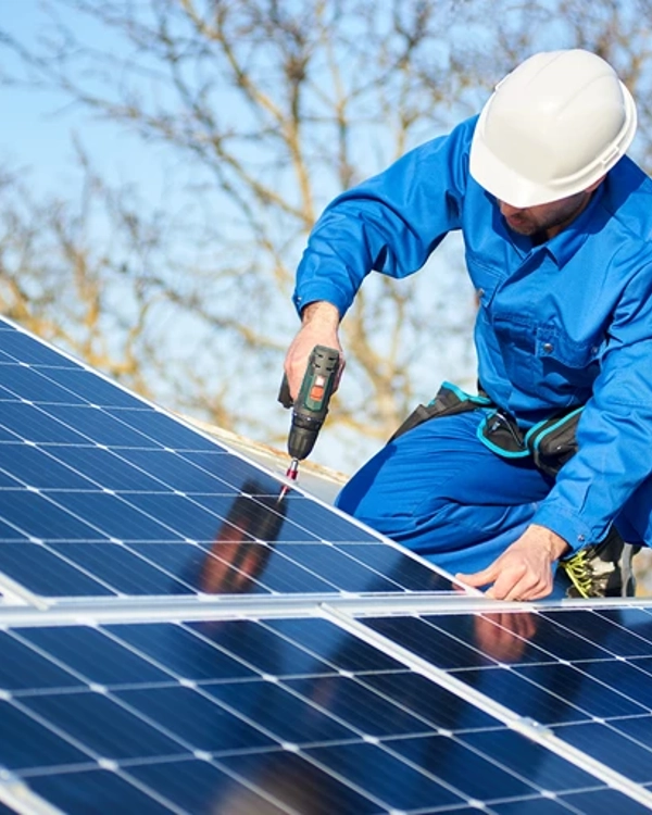 Photograph of a male engineer screwing in solar panels Photograph of a male engineer screwing in solar panels