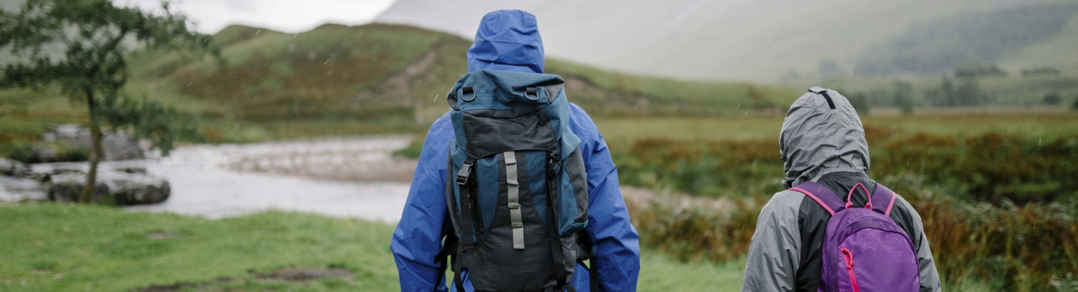 A couple trekking through the rain in the Scottish Highlands. A couple trekking through the rain in the Scottish Highlands.