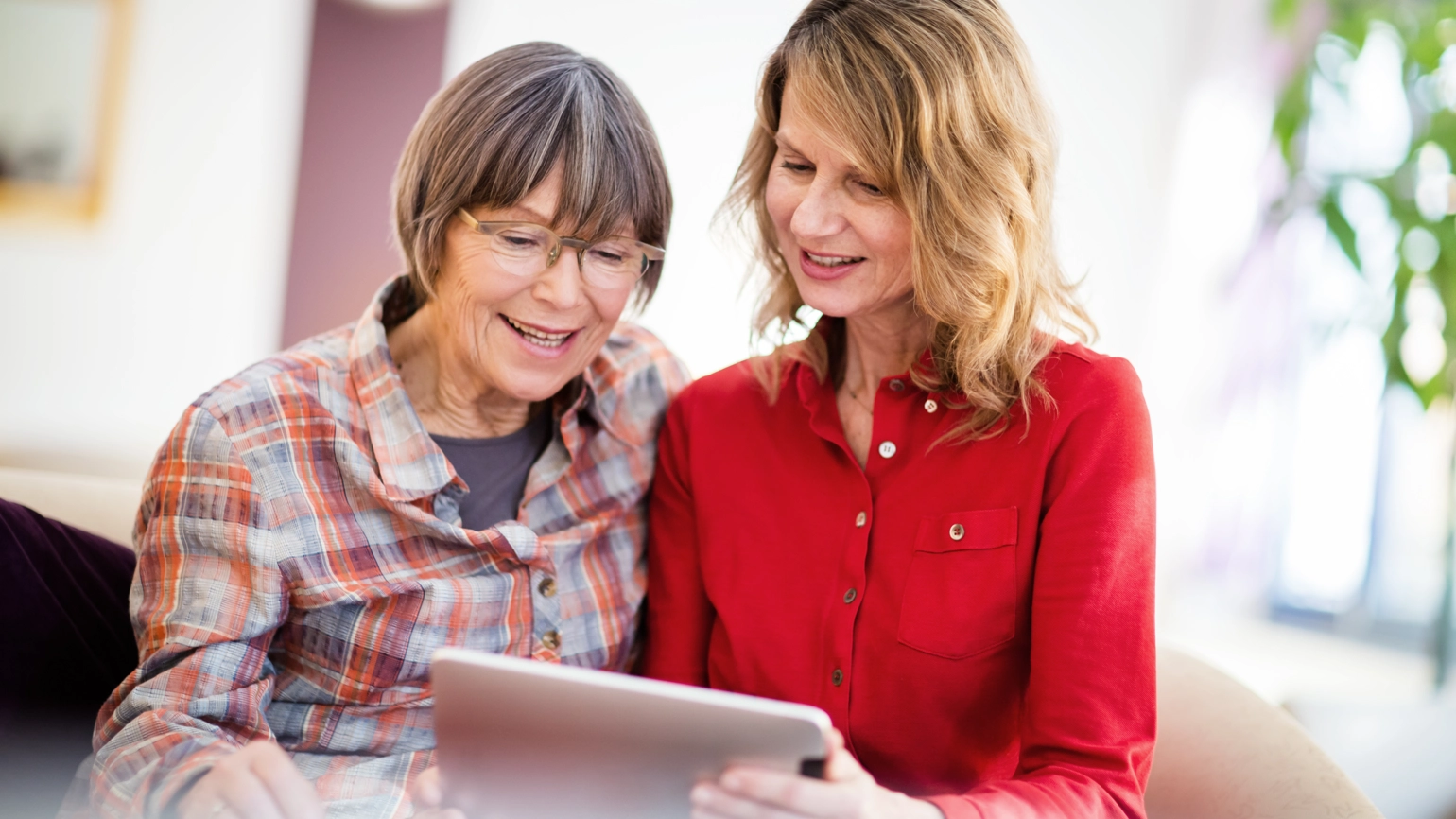 Two middle aged female checking their touch pad Two middle aged female checking their touch pad