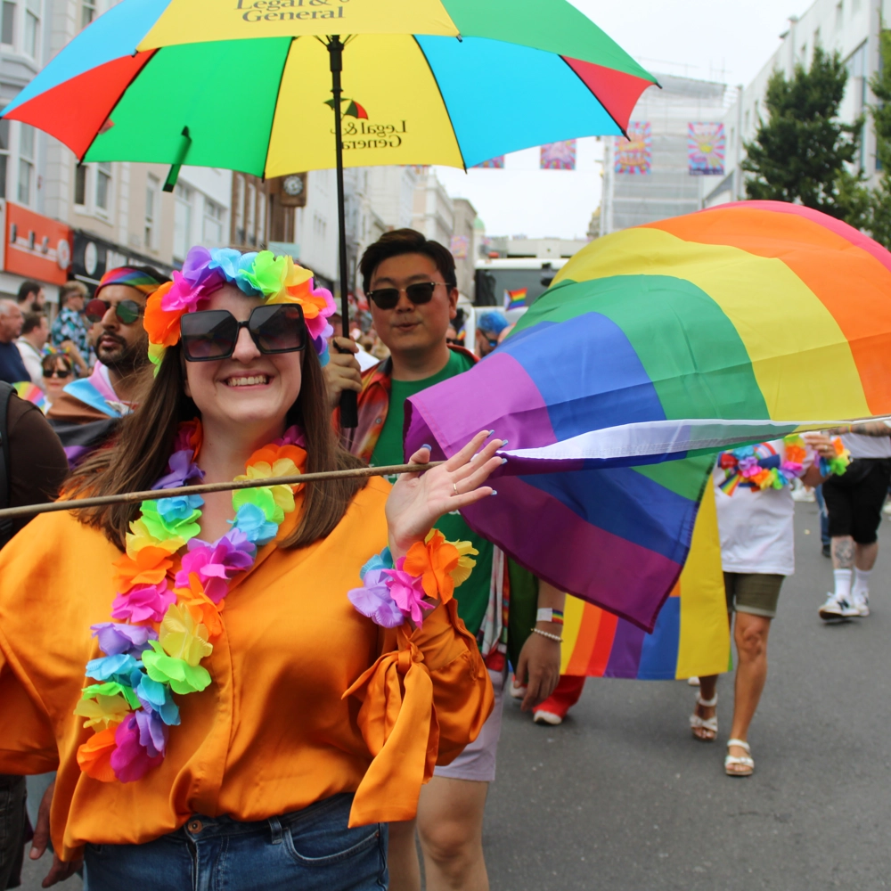 An L&G employee marching in a pride parade, waving a rainbow flag. An L&G employee marching in a pride parade, waving a rainbow flag.