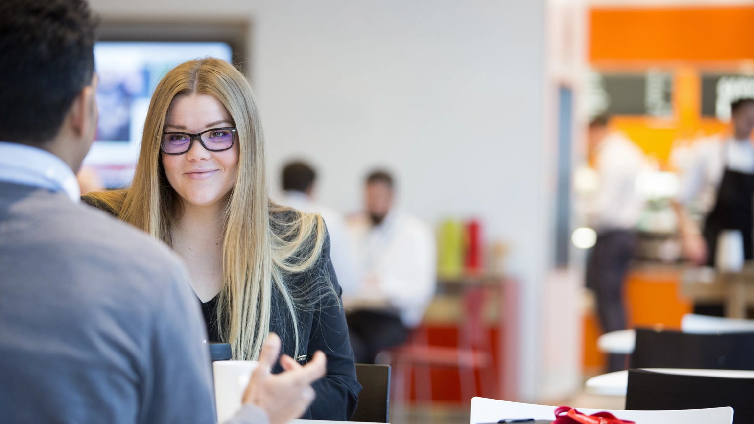 Female and male colleague chatting in office open space Female and male colleague chatting in office open space