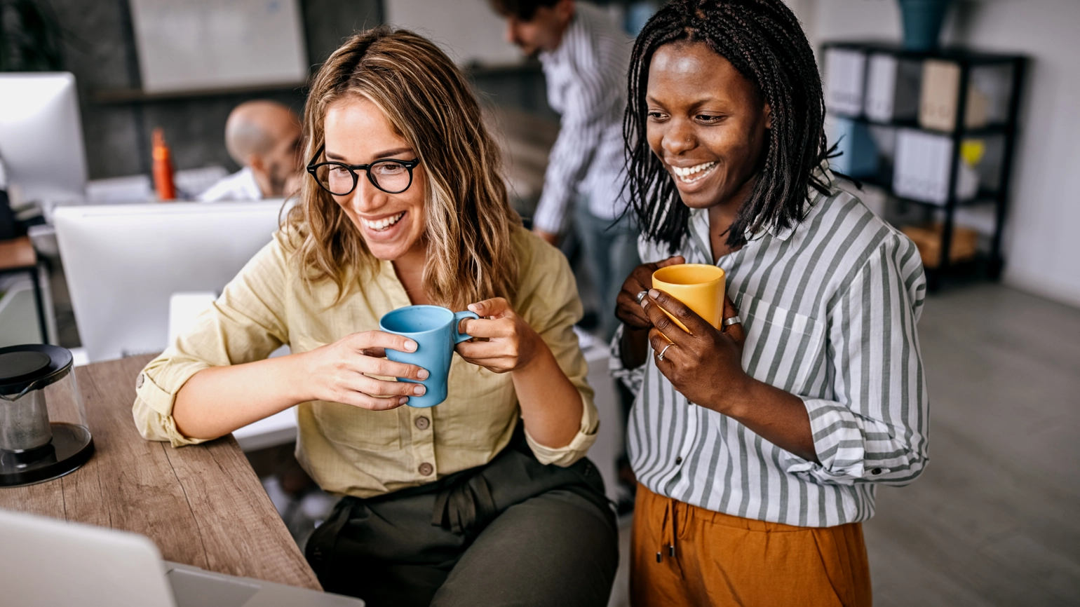 Two female colleague talking through laptop Two female colleague talking through laptop