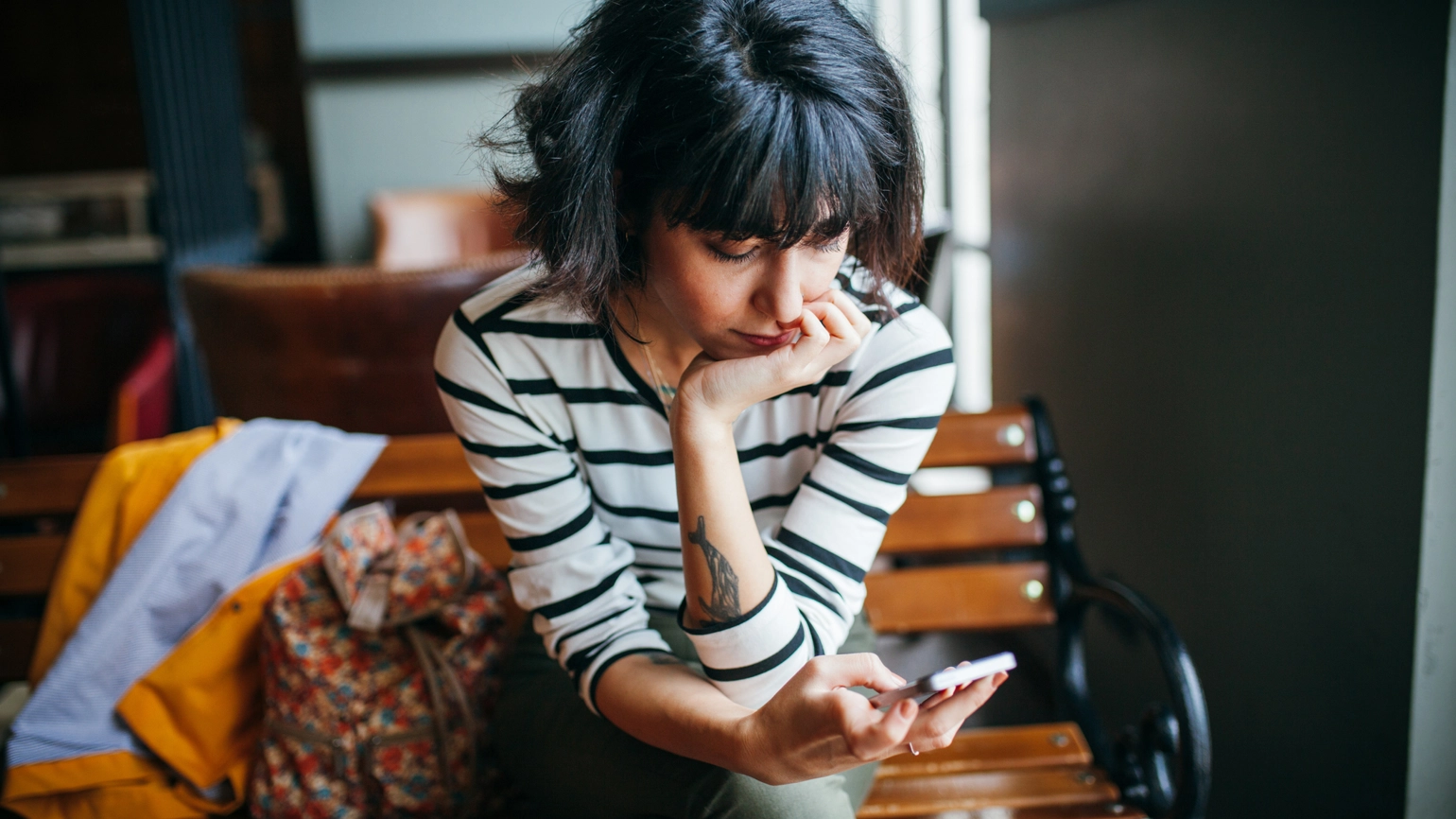 Young female looking at her phone in bench Young female looking at her phone in bench